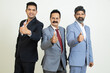Group of positive indian business people wearing suit doing thumbs up while looking at camera isolated on white studio background. Corporate Concept.