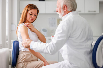 Doctor disinfecting patient's vaccine application spot