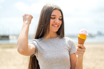 Wall Mural - Teenager girl with a cornet ice cream at outdoors celebrating a victory