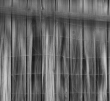 Black And White Abstract Of Wire Fence In Front Of Wooden Fence Abstract Blur Up And Down Vertical Movement Created By Slow Shutter Speed And In Camera Movement Creating Blurry Streaks  Backdrop 