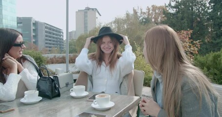 Wall Mural - Three women checking the hat over coffee