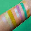 Pastel spring and summer eye shadow swatches, dry powder, set of colorful brush strokes on skin. Cosmetic makeup texture samples, smear trace samples on pink background. Realistic photography