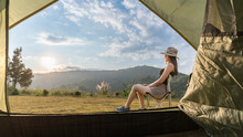 Asian Woman Sitting In Front Of A Tent Watching The Sunrise Amidst Beautiful Nature Khao Kho In Thailand.