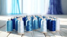 Different Shades Of Blue Colored Sewing Thread Spools On White Table.