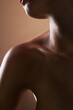 © LuneVA/peopleimages.com - Skincare, wellness and closeup with neck of person in studio for health, textures and cosmetics. Beauty, body and aesthetic with zoom of woman on brown background for glow, dermatology and glamour