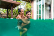 © oneinchpunch - Couple of lovers in a beautiful tropical villa with swimming pool - Handsome man and pretty young woman having fun and relaxing in the home garden during summer vacation