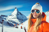 Young woman wearing sunglasses and ski equipment in ski resort on Matterhorn, winter holiday concept.