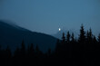 Moon in the mountains landscape with coniferous trees