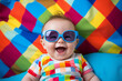 © deagreez - Created by generative AI portrait of happy positive funny baby wearing stylish big colored sunglasses