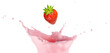 Strawberry falling into a milky pink splash isolated on white background. Studio photograph of strawberry yogurt, milkshake or smoothie.