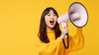 Cheerful of cute Asian woman holding megaphone making announcement.
