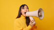 © JKLoma - Cheerful of cute Asian woman holding megaphone making announcement.