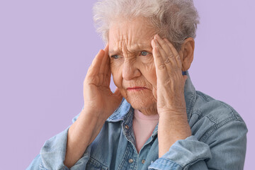 Canvas Print - Stressed senior woman on lilac background, closeup