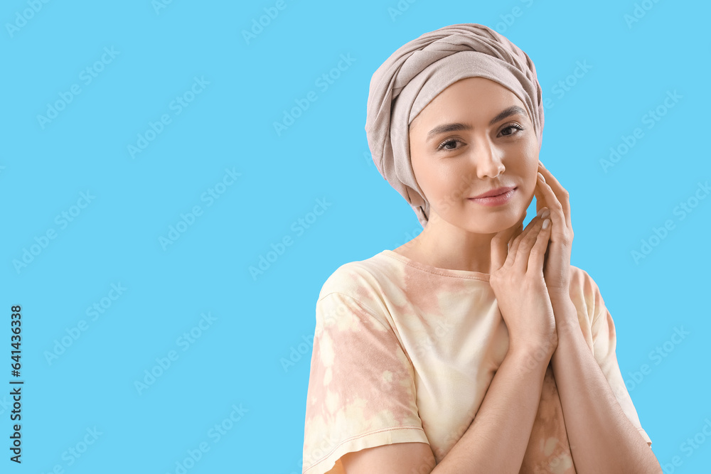 Young woman after chemotherapy on blue background, closeup