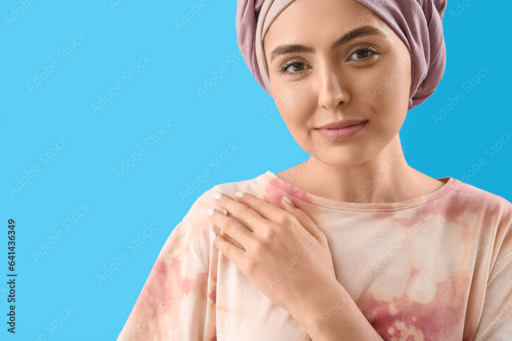 Young woman after chemotherapy on blue background, closeup