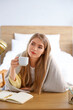 © Pixel-Shot - Thoughtful young woman with cup of coffee at table in bedroom