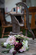 Antique water pump with a bridal bouquet of flowers in front of it. 
