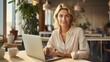© ISVO - Portrait of a beautiful business woman student in a white shirt with blond hair sitting and working at a laptop at her workplace in a bright open space office entrepreneur professional manager