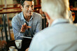 © Marko Geber - Diverse group of coworkers from a business company having a meeting in a cafe bar in the city