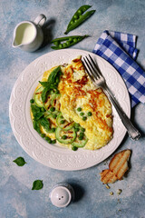 Wall Mural - Delicious omelet with green vegetables ( sweet peas and zucchini ) for a breakfast. Top view with copy space.