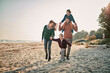 © Marko Geber - Young happy caucasian family walking the beach during winter