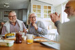 © Marko Geber - Group of senior friends having breakfast in the morning in the kitchen