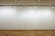 Interior of an empty white wall with spot lights at art gallery