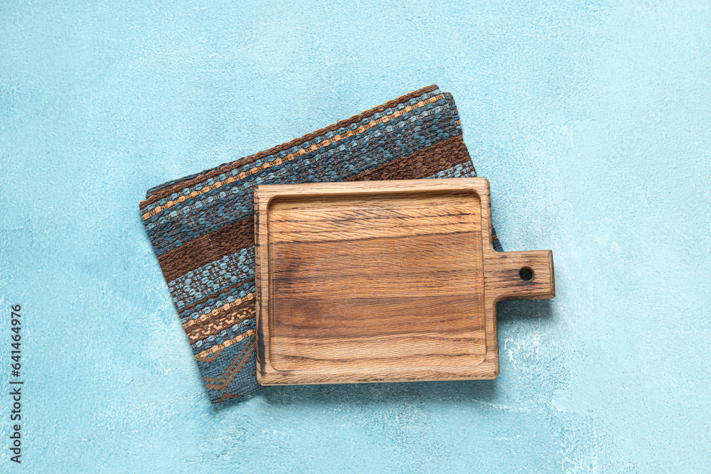 Wooden board with napkin on grunge blue kitchen table
