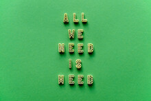 Close-up View Of Creative Transformed Quote ‘All We Need Is Weed’ Made Up Of Alphabet Pasta Letters Against Green Background 
