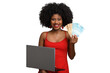 © Edson Souza - woman holds brazilian money and laptop looking at camera, black woman