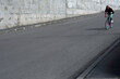 © TrueFrame Collective - Young long-haired bearded man going down the asphalt road by vintage bike with blue rims