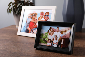 Canvas Print - Frames with family photos on wooden table indoors