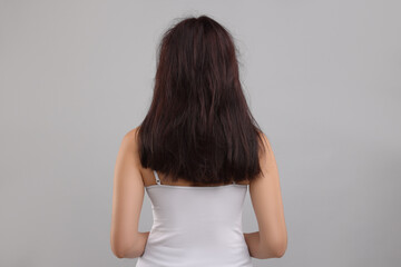 Wall Mural - Woman with damaged hair on light grey background, back view
