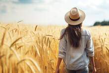 Back View Of A Woman Wearing Hat Walking In The Ripe Wheat Field