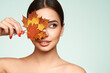 © Oleg Gekman - Portrait of beautiful young woman with autumn leafs. Healthy clean fresh skin natural make up beauty eyes and red nails