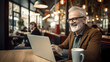 © AspctStyle - Happy old man working on laptop in a cafe restaurant. Busy mature professional business man using laptop sitting in cafe.