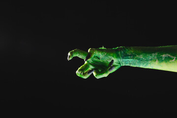 Poster - Green monster hand with black nails reaching on black background