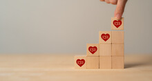 Business Engagement, Creating Business Partnerships Concept. Building Trust, Relationships, Increase Customer Loyalty And Advocacy. Wooden Cube Blocks With Red Hearts And TRUST Icon On Background.