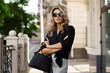 © Svetlana Sokolova - Outdoor portrait of beautiful  blond woman  in sunglasses with perfect wavy hairs  holding luxury hand bag. Fashion acsessories , Casual outfit.
