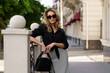 © Svetlana Sokolova - Outdoor portrait of beautiful elegant blond woman with perfect wavy hairs  holding luxury hand bag. Fashion acsessories, sunglasses.