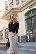 © Svetlana Sokolova - Elegant luxury blond woman with perfect wavy hairs , make up , sunglasses posing outdoor. Casual outfit.