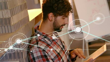 Poster - Animation of dots connected with lines over caucasian smiling businessman working on digital tablet