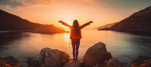 Confident woman with arms up relaxing at sunset seaside during a trip , traveler enjoying freedom in serene nature landscape