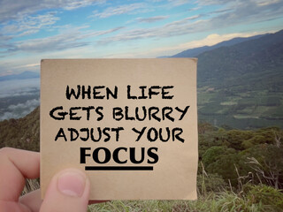 Wall Mural - Motivational and inspirational wording. When Life Gets Blurry Adjust Your Focus written on a notepad. With blurred styled background.