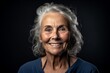 © Markus Schröder - Headshot portrait photography of a satisfied mature woman smiling against a deep indigo background. With generative AI technology