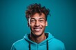 © Markus Schröder - Headshot portrait photography of a happy boy in his 20s giving a hug to the camera against a teal blue background. With generative AI technology