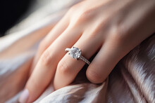 Close-up Of A Young Woman Wearing A Diamond Ring On Her Left Ring Finger, A Gift From A Marriage Proposal. Happiness Concept Suitable For Marriage Or Engagement.