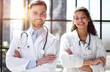 © Katsiaryna - a female doctor and a male doctor are standing in the office with their arms crossed