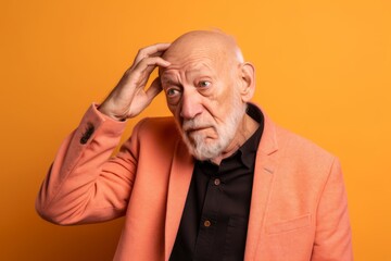 Wall Mural - Medium shot portrait photography of a glad old man scratching head in gesture of confusion against a pastel orange background. With generative AI technology