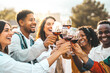 © Davide Angelini - Young people toasting red wine glasses at farm house vineyard countryside - Happy friends enjoying happy hour at winery bar restaurant - Guys and girls having rooftop house party together